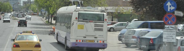 Blick durch die Frontscheibe auf eine befahrene Strße mit Oberleitungsbus