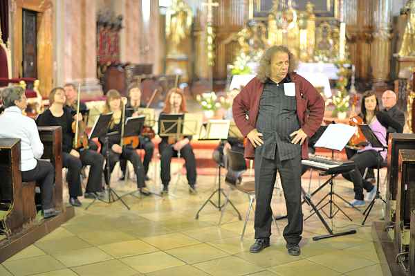 Kantor Vorrath blick etwas hilflos, Orchester im Hintergrund