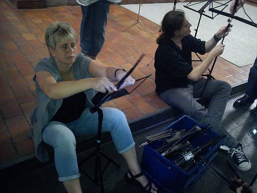 Zwei Musiker am Bühnenrand sitzend Notenständer aufklappend