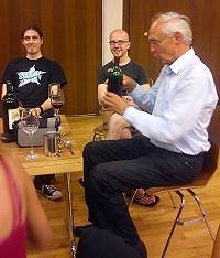 Der Pfarrer in fröhlicher Runde beim Wein einschenken