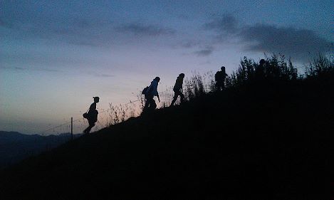 Chorfahrer bergaufziehend als Silhouette vorm Sonneaufgang