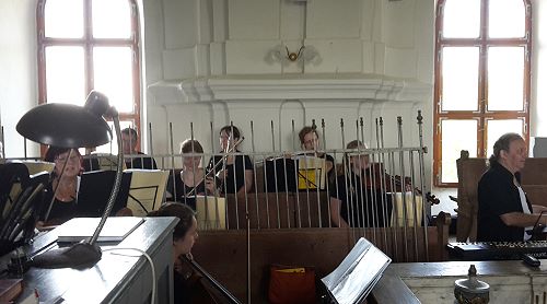 Orchester sitzt hinter in der Kirche abgestellten Zäunen