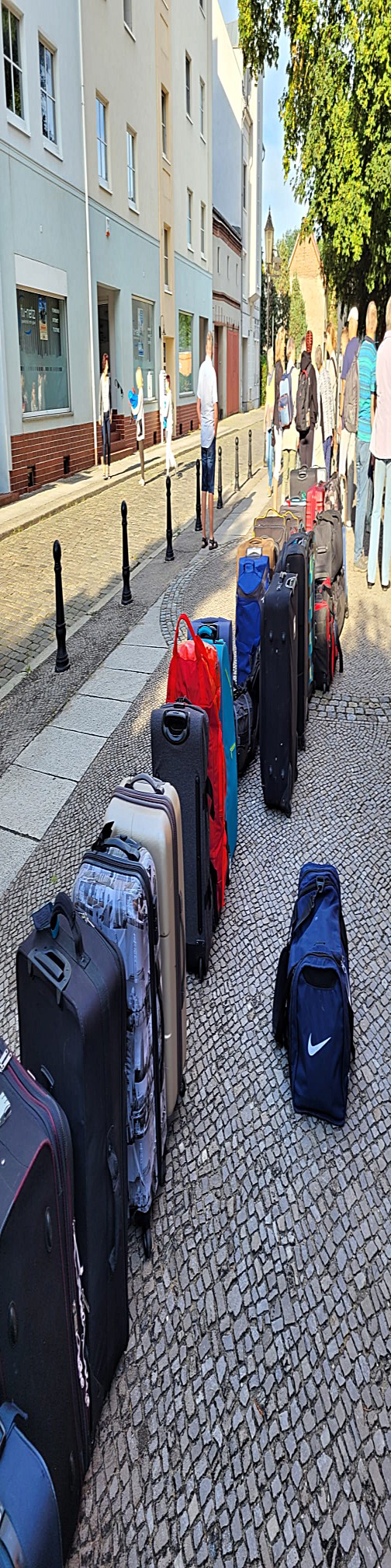 Reihe mit Koffern und anderem Gepäck auf der Straße vor der Klosterkirche